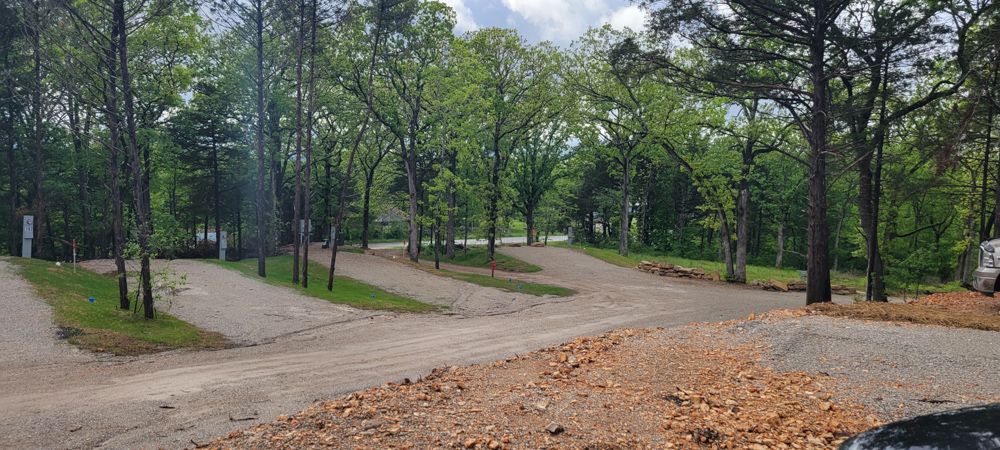 A junction of tree-lined gravel roads leading to wooded, well-spaced RV sites.